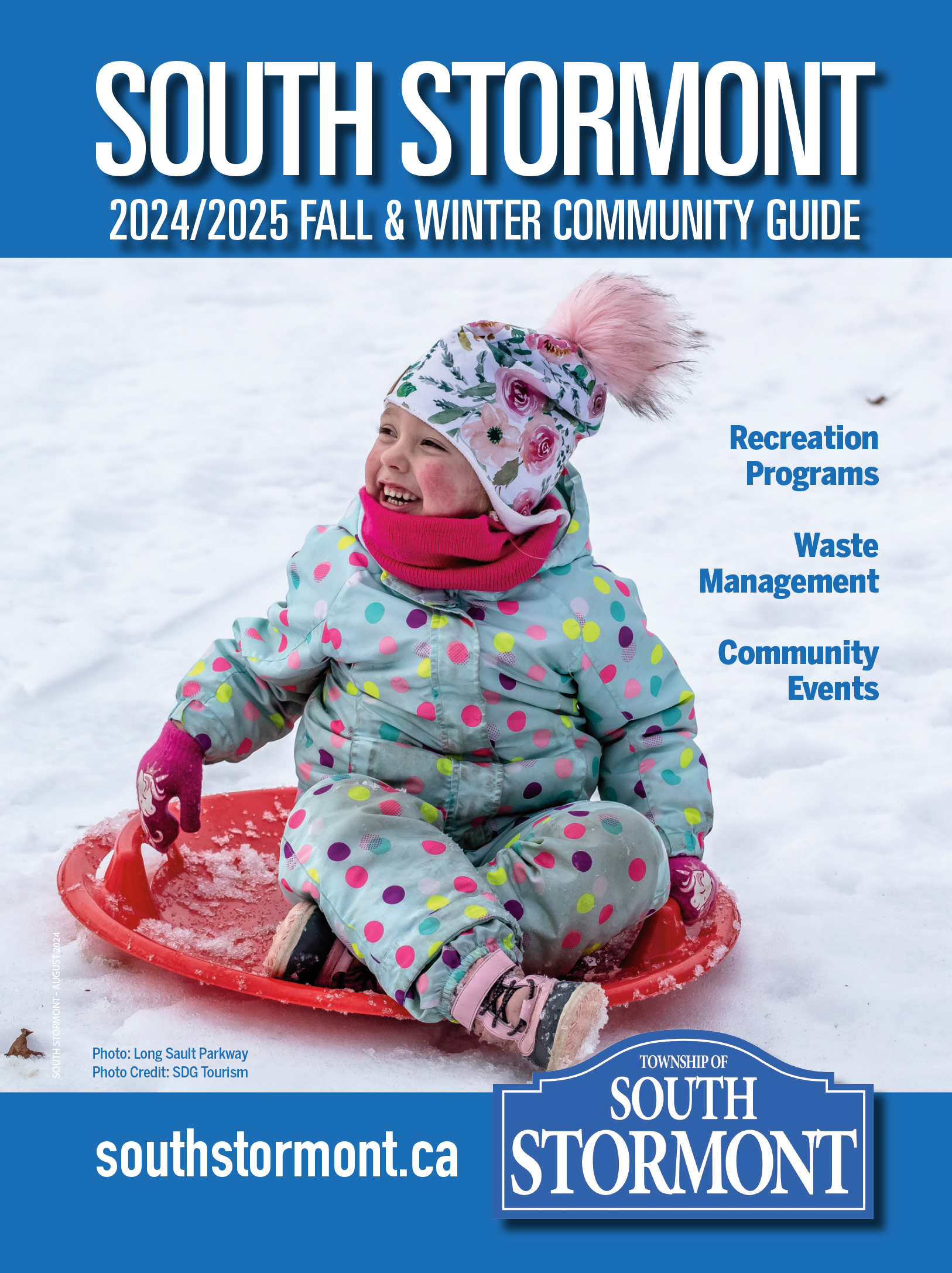 Young girl sliding on toboggan down a snow hill